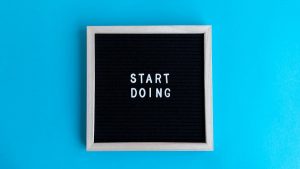 Black letter board with 'START DOING' text on a vibrant blue background.